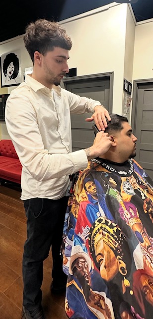 Barber in white shirt cutting hair